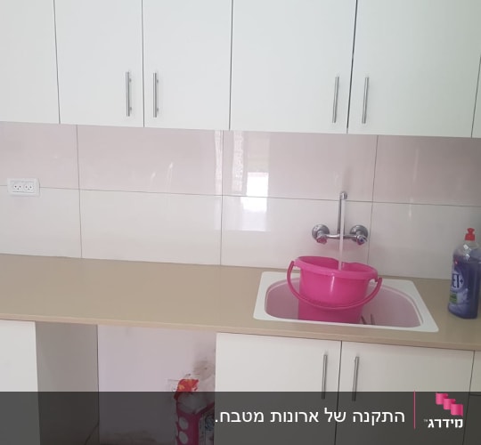 כיור במטבח עם קערה ורודה וסבון כלים